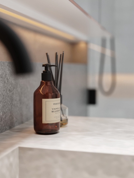 Cosmetic bottle on a grey sink by Studium Dekor.
